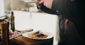 Un traiteur sert un dîner dressé dans une maison.