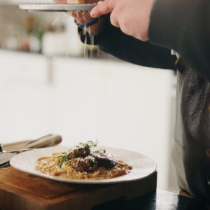 Un traiteur sert un dîner dressé dans une maison.